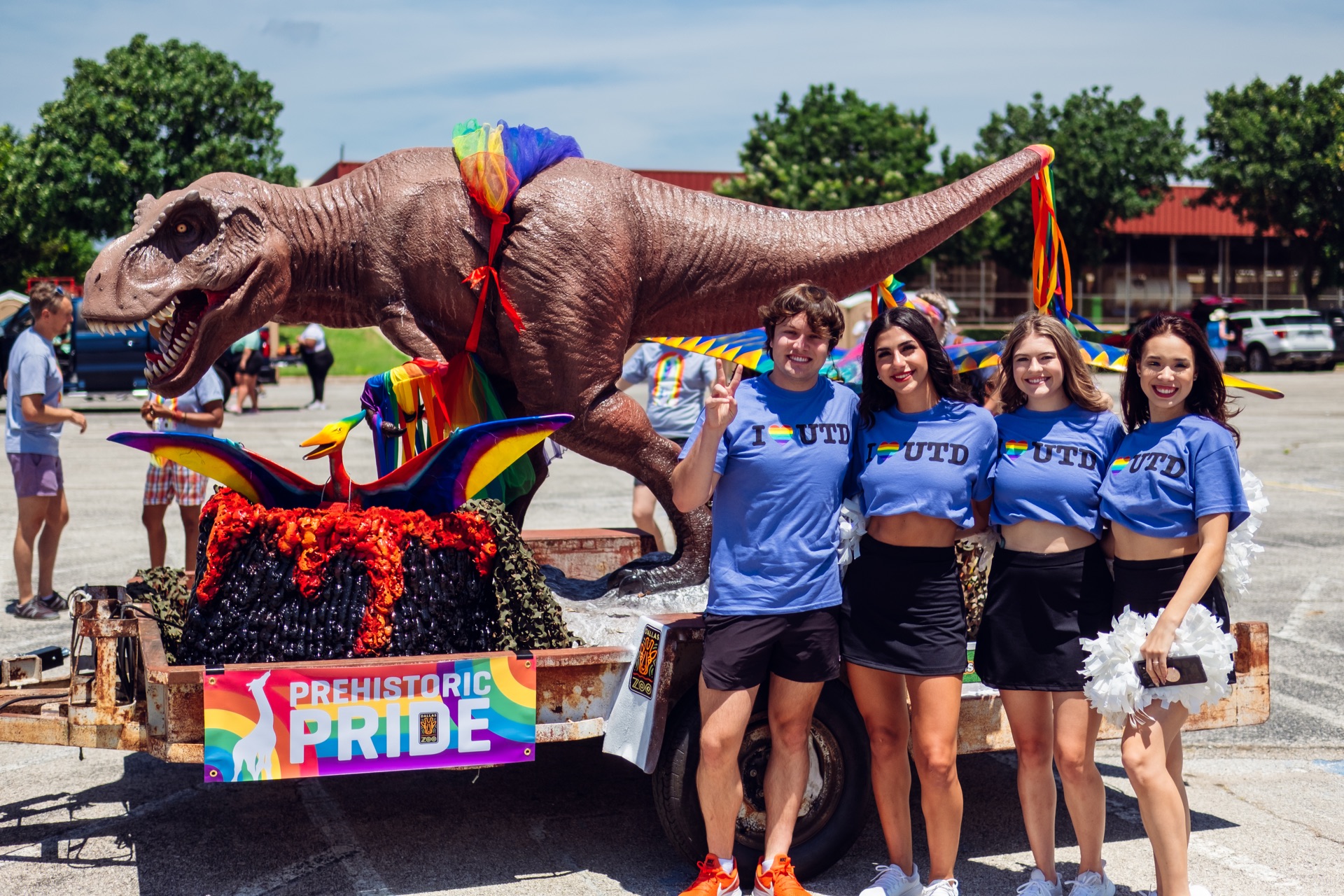 A Few of the UTD Cheer Squad Pose Next to a Pride Parade Float